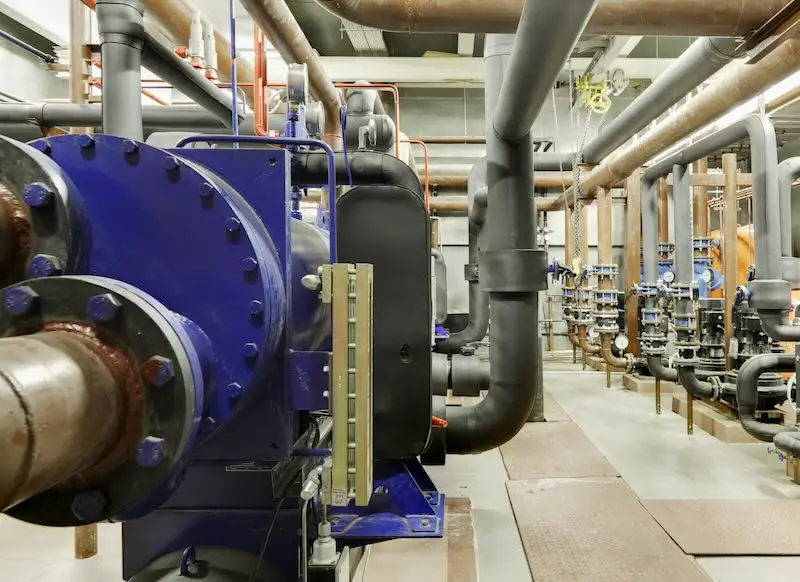 Retro commissioning: The Benefits? Machine room with pipes and cooling equipment.
